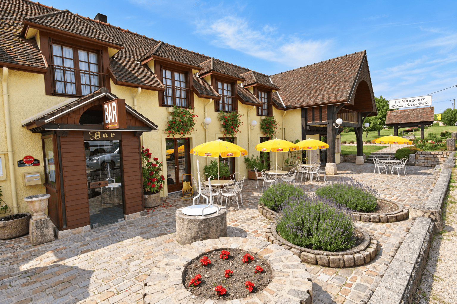 Terrasse fleurie et entrée du bar de La Mangeoire